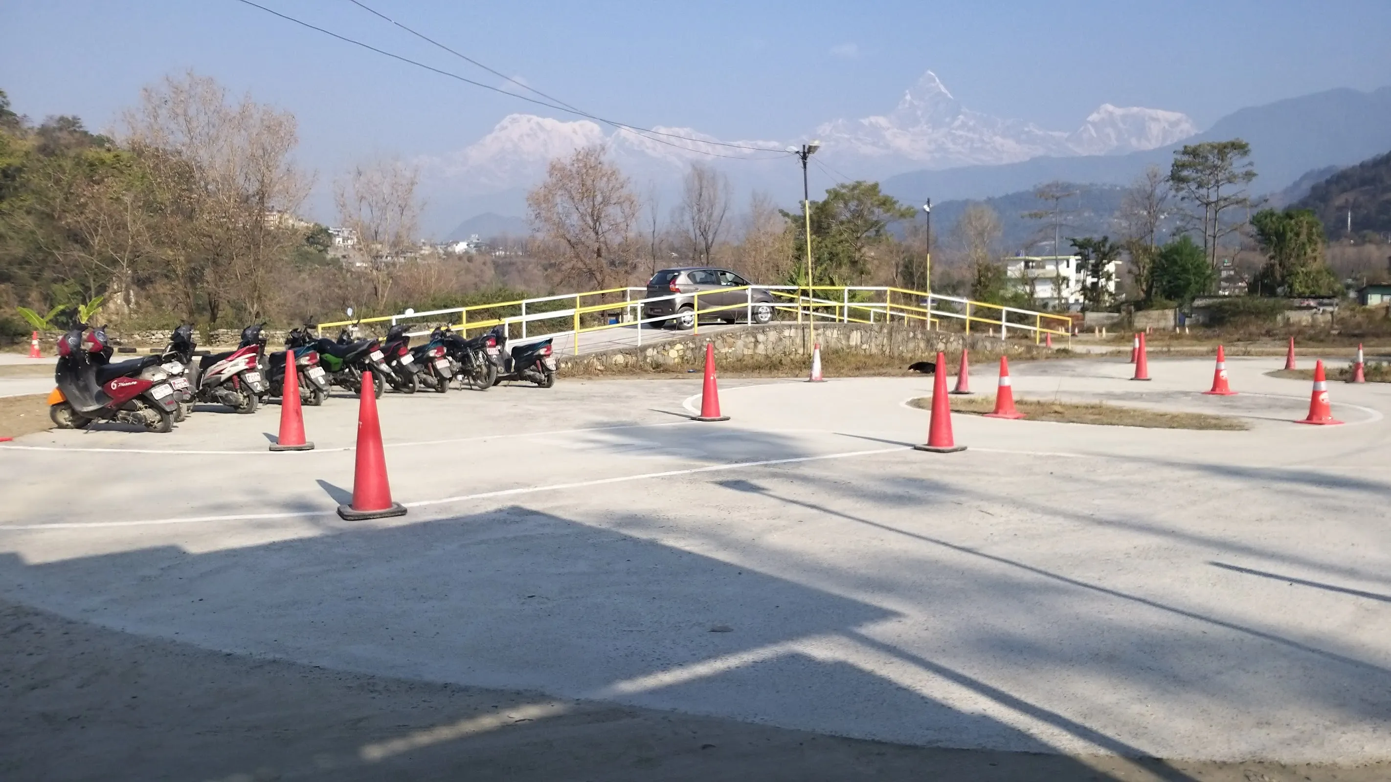 Motorbikes parked at the training ground with the Annapurna range behind