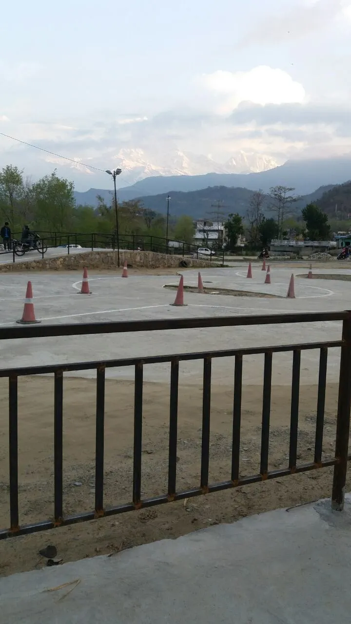 Cones lined up at dusk with the mountains visible behind the fence