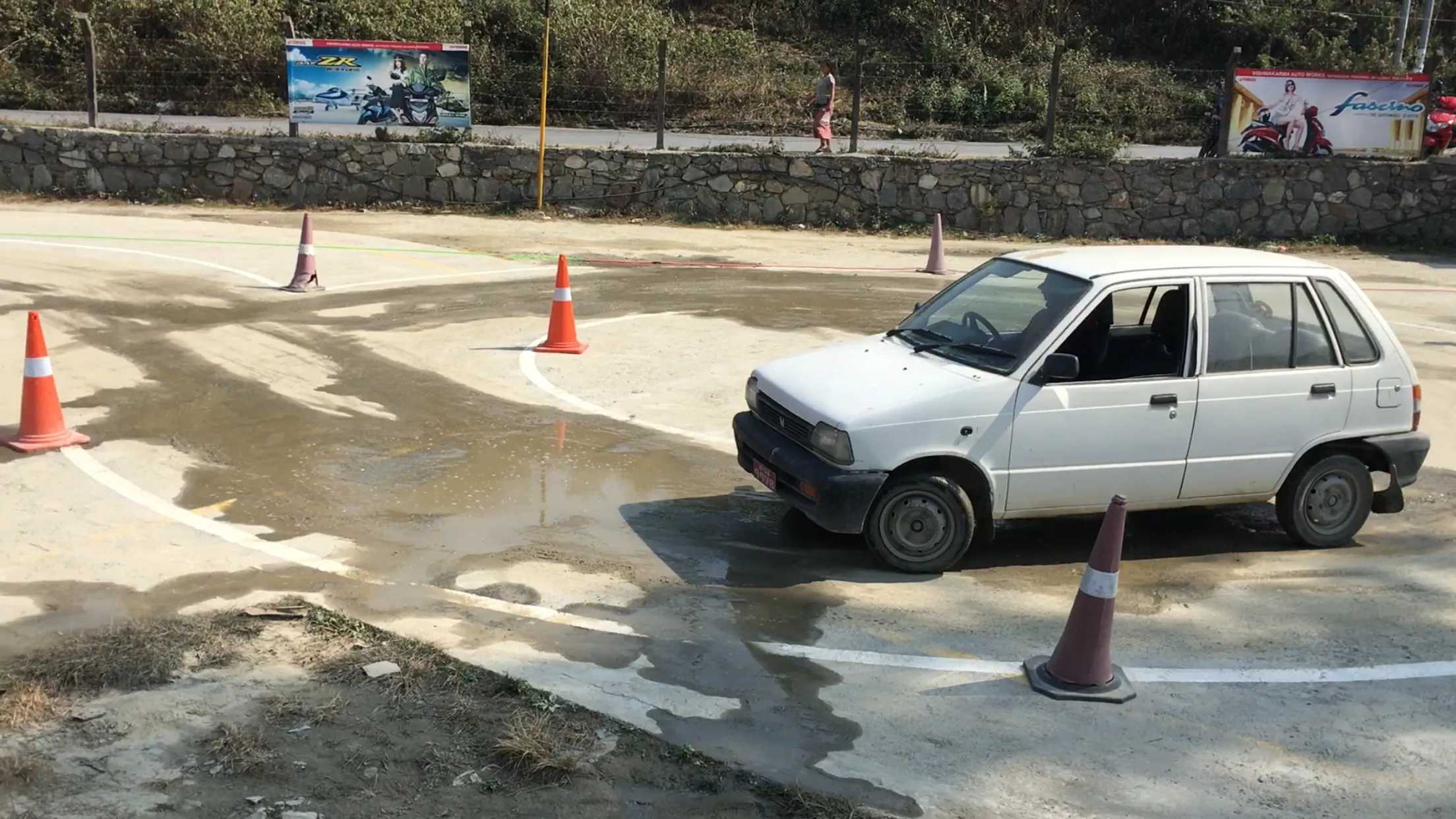 Driving instructor coaching a student on a curved practice line